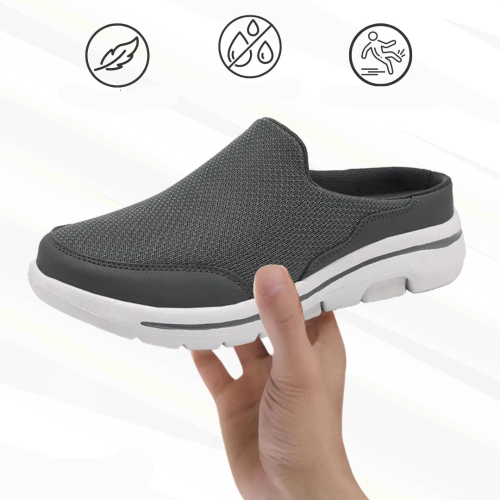 Dark grey mesh slip-on mule with white sole held up in a hand, with three small feature icons above. 9