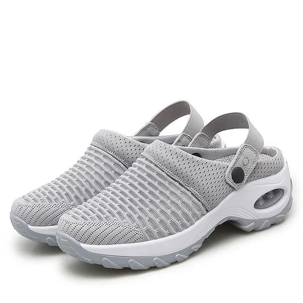 Pair of light grey mesh slip-on clogs with heel straps, snap buttons and a white air-cushion sole, shown on a plain background. 1