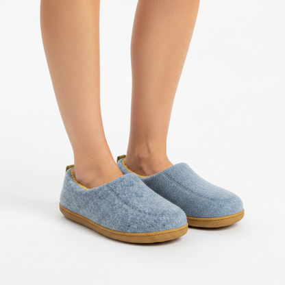 Woman's bare legs wearing the light blue slippers with tan soles, standing on a white background. 3