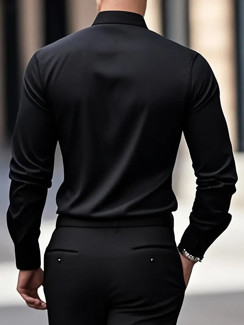 Back view of a model wearing the black shirt with black trousers, hand in pocket, showing the smooth back. 15