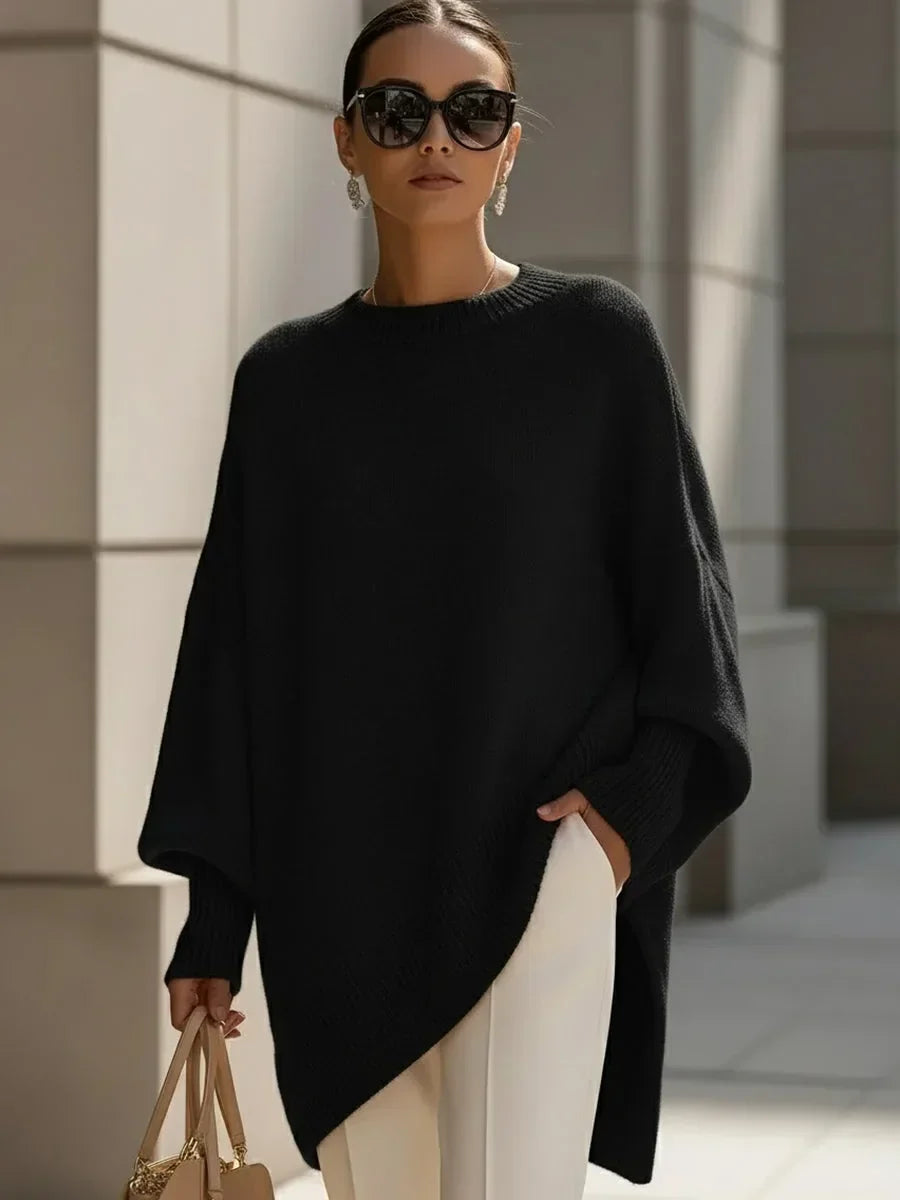 Model wearing the black version of the oversized jumper with white trousers and sunglasses 6