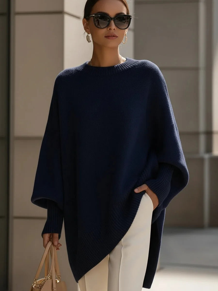 Model wearing the navy blue version of the jumper with sunglasses and a beige handbag 8