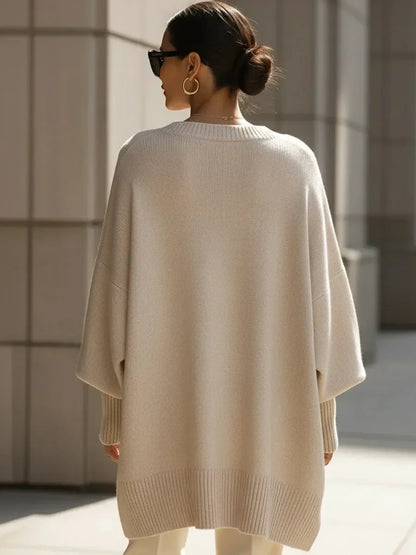 Back view of the cream jumper on a model, showing the ribbed hem and loose batwing sleeves 4