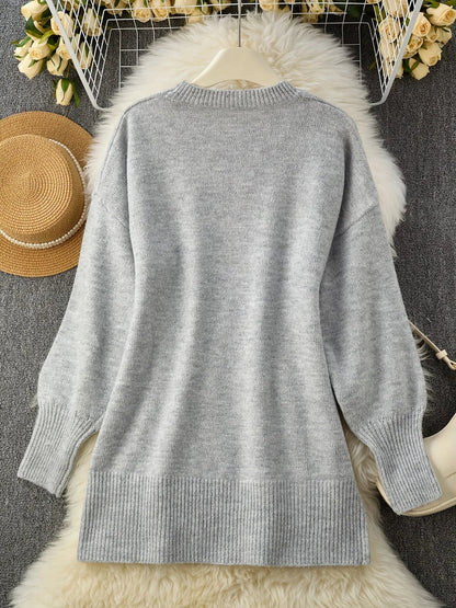 Grey jumper laid flat on a hanger over a fluffy rug, with a straw hat and flowers 10