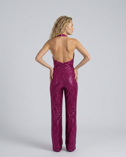 Back view of the fuchsia sequin jumpsuit, model with hands on hips showing the open back 18