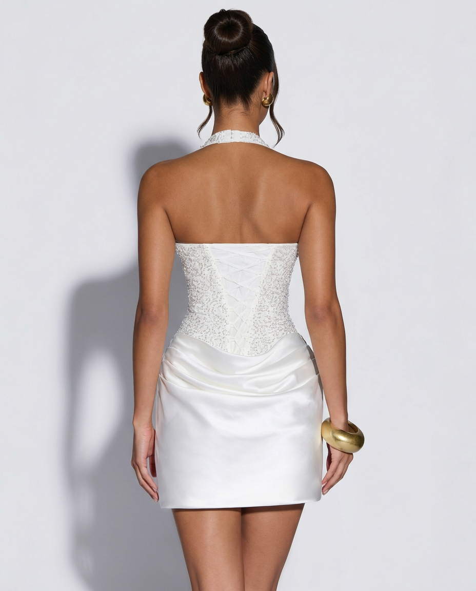 Back view of the white dress showing the lace-up corset back, beaded bodice and ruched satin skirt 5