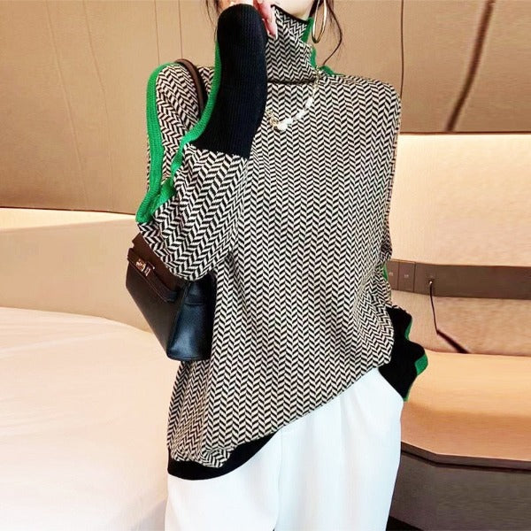 Model wears the black and white herringbone high-neck jumper with green side stripes, white trousers and a black handbag on her shoulder. 2