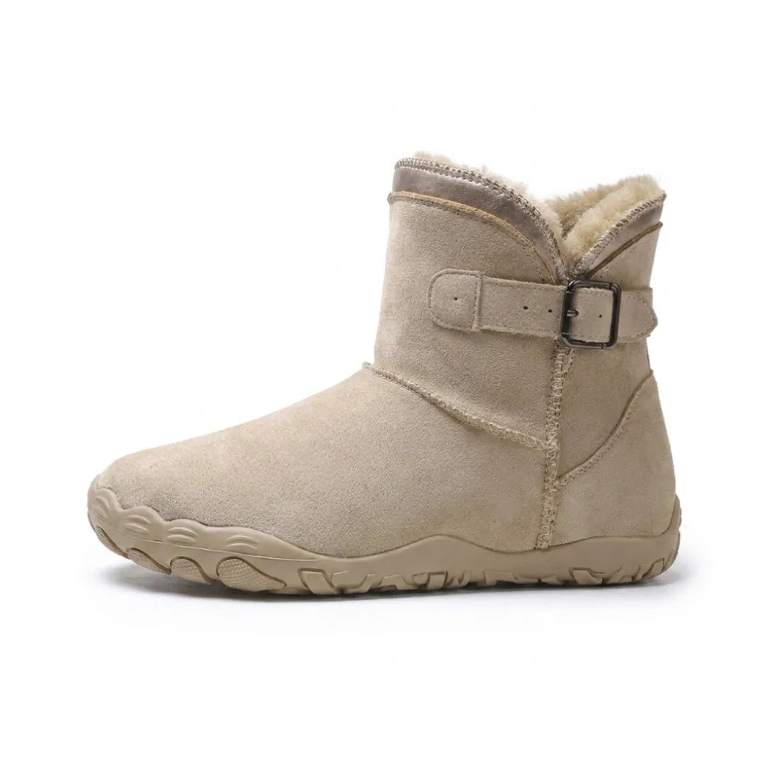 Side view of a single beige suede ankle boot with fleece lining and buckle strap 1