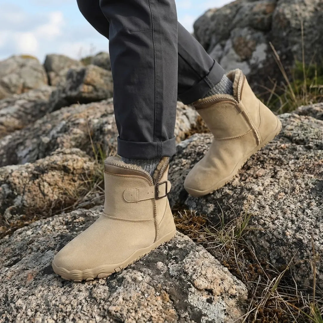 Beige boots worn on rocky ground with grey trousers and socks, showing the fleece collar 2