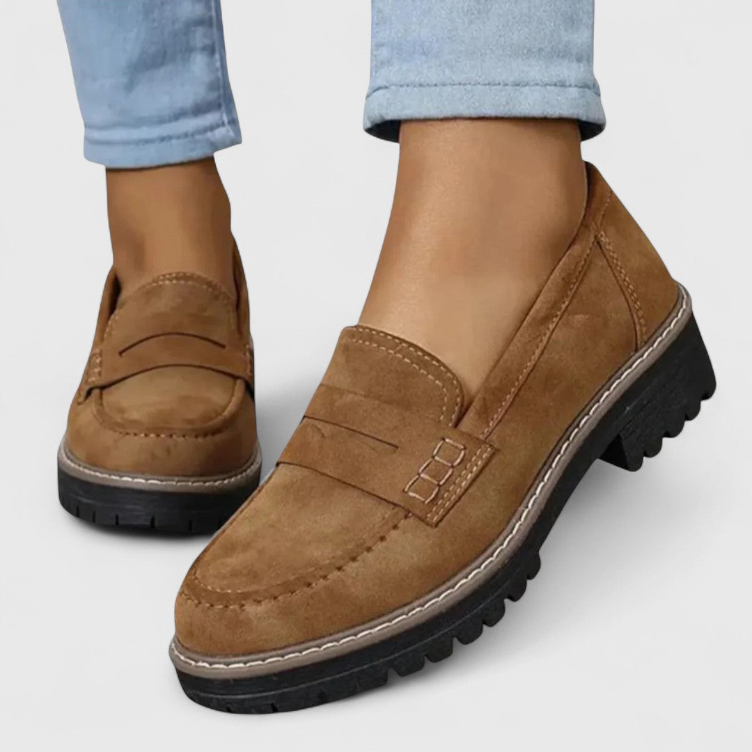 Tan brown suede-look loafers with visible stitching, worn with light blue jeans 5