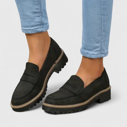 Black suede-look loafers with contrast stitching, worn with light blue cropped jeans 1