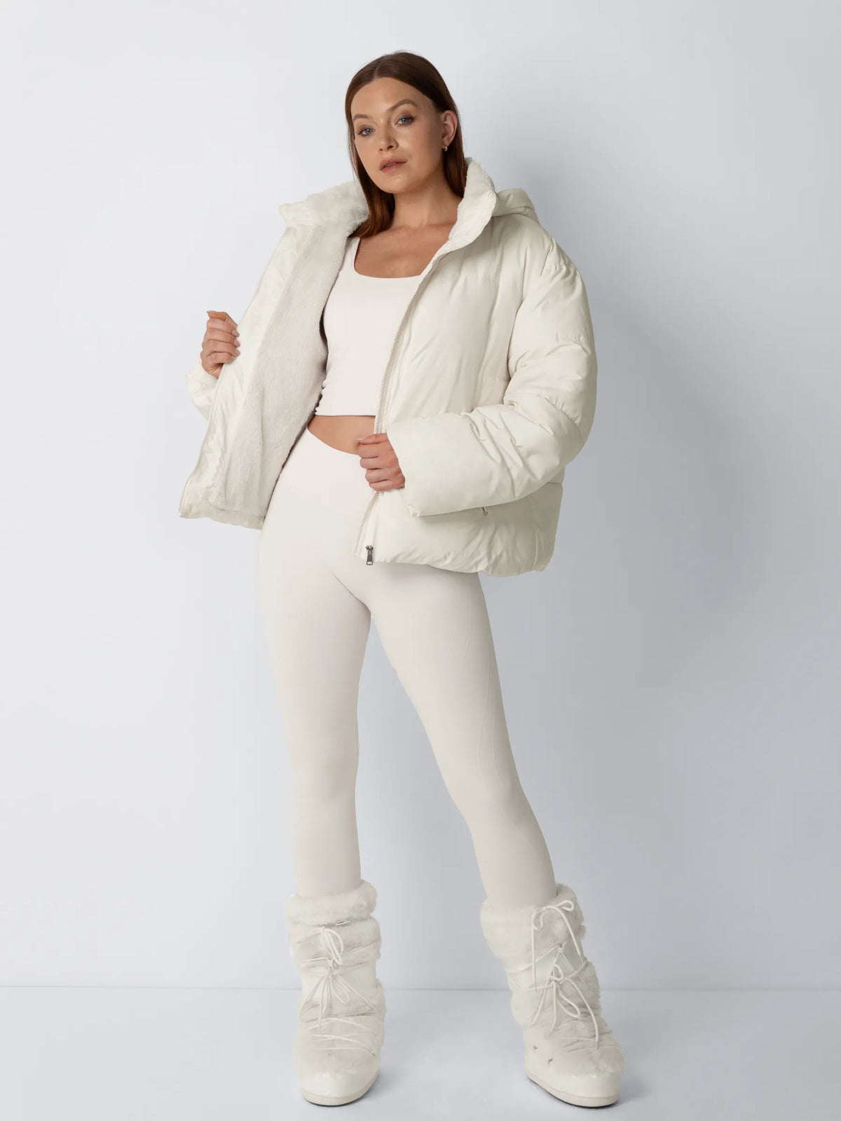 Full-length view of a model in a cream puffer jacket held open to show the soft fleece lining 2