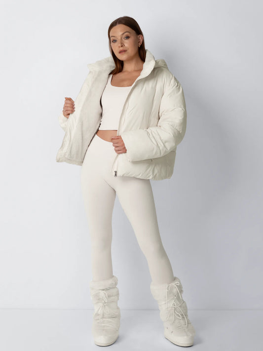 Full-length view of a model in a cream puffer jacket held open to show the soft fleece lining 2