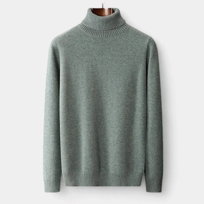 Front view of the sage green roll-neck jumper hanging on a wooden hanger, ribbed collar and cuffs 1