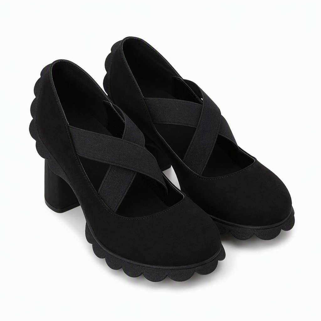 Pair of black suede-look block heel shoes with crossed elastic straps and scalloped sole on a white background. 8