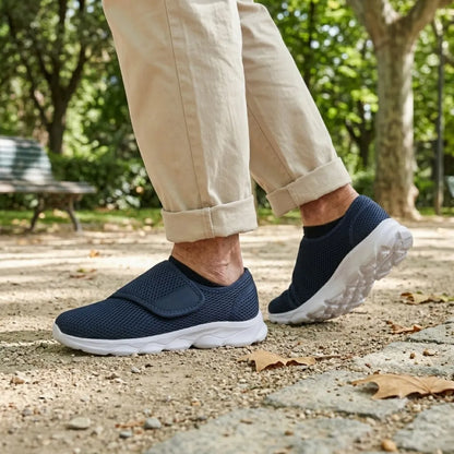 Navy mesh shoes worn by a walker in beige trousers on a sunlit park path 2