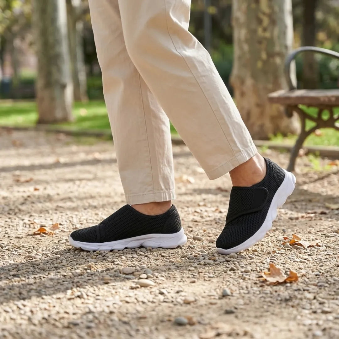 Black mesh shoes with white soles worn by a walker in beige trousers on a park path 20