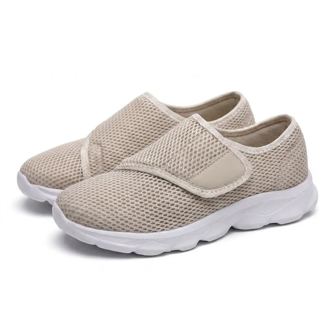 Pair of beige mesh shoes with white soles and hook-and-loop straps, seen from the front three-quarter 34