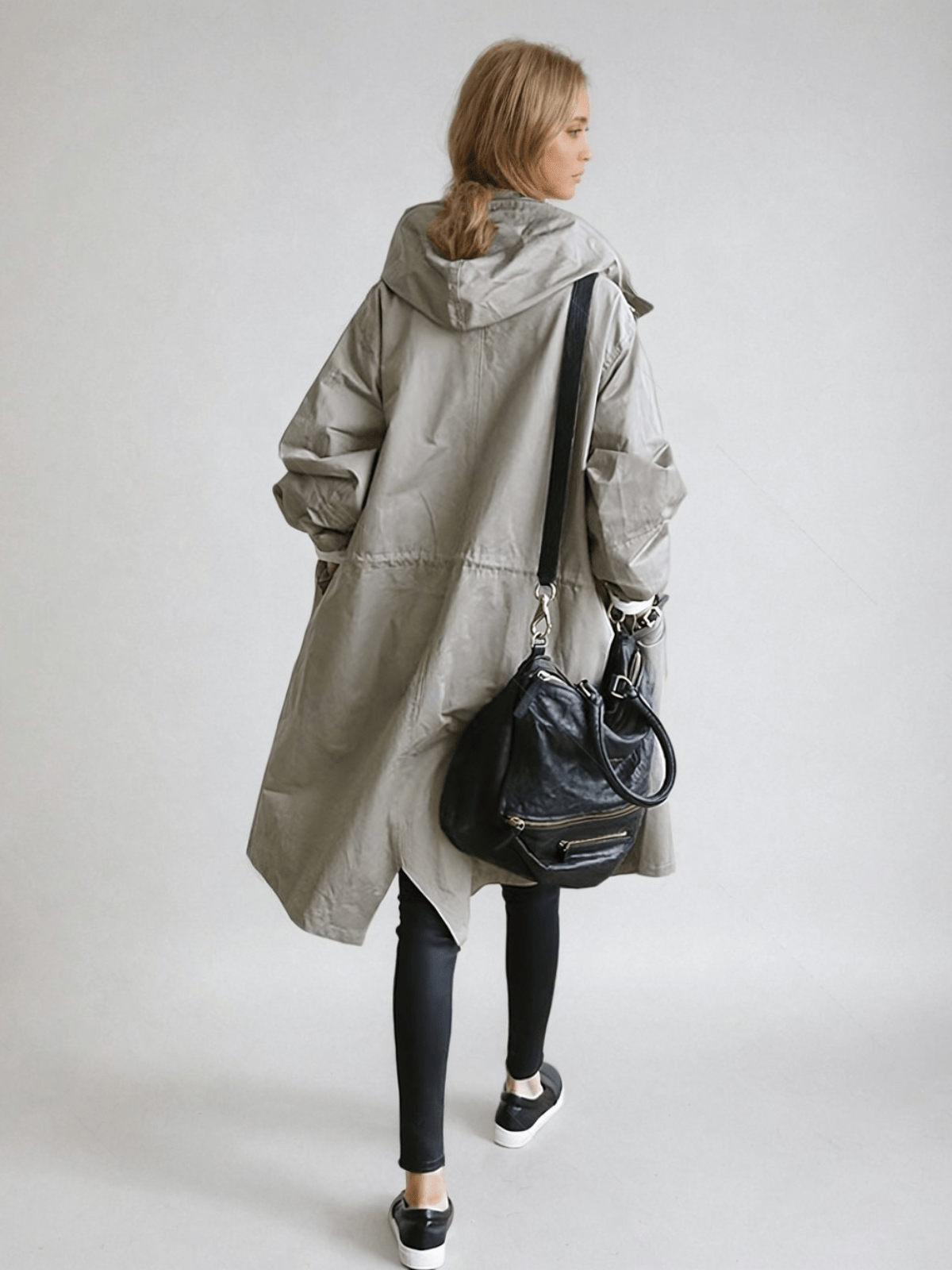 Back view of the grey hooded coat showing the drawstring waist, worn with a black shoulder bag 4