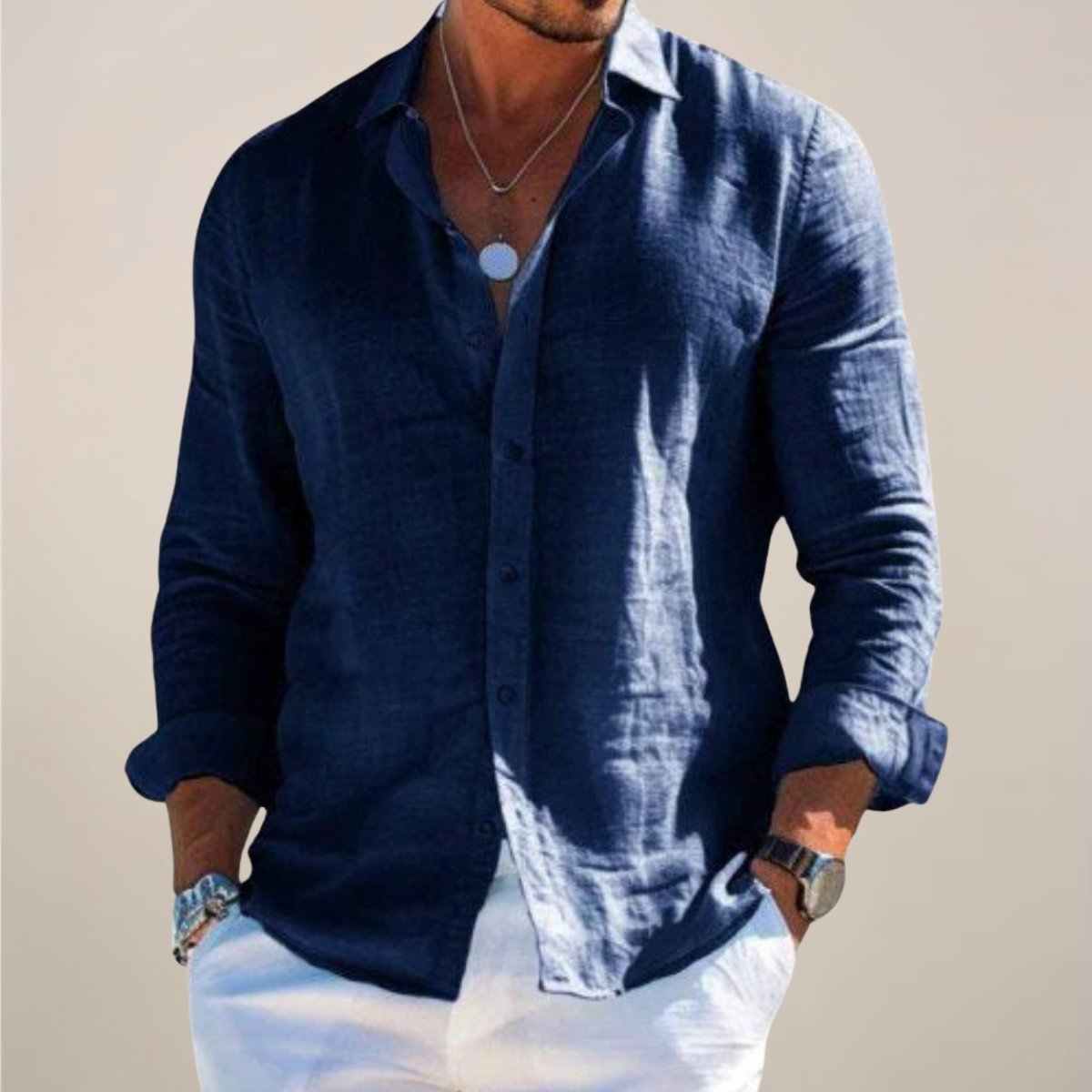 Model wearing the navy blue version of the shirt, buttoned with sleeves rolled up, hands in pockets of white trousers. 5