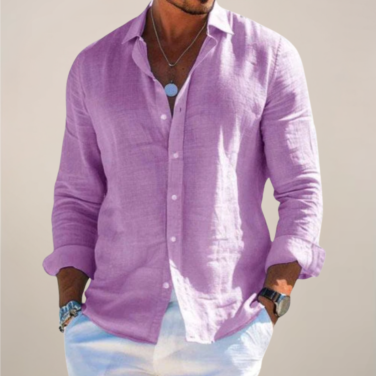 Model wearing the lilac purple version of the shirt, buttoned with sleeves rolled up, hands in pockets of white trousers. 6