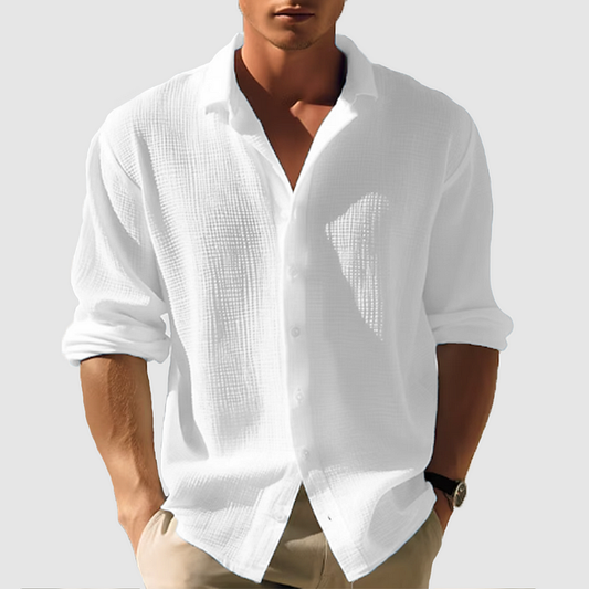 Model wearing the textured shirt in white, sleeves rolled, hands in beige trouser pockets 2