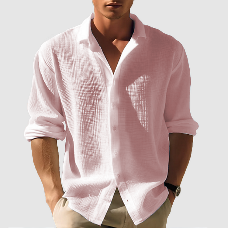 Model wearing the textured shirt in soft pink, sleeves rolled, hands in beige trouser pockets 4