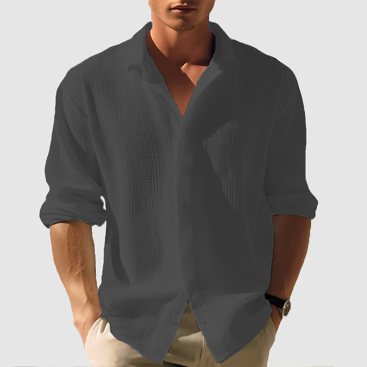 Model wearing the textured shirt in dark charcoal grey, sleeves rolled, hands in beige trouser pockets 7