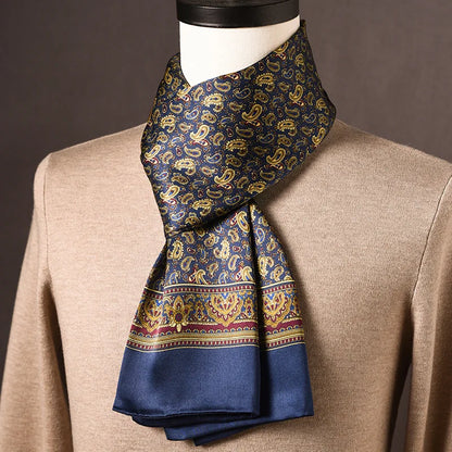 Navy silk scarf with gold paisley print, a burgundy and gold ornate border and plain blue ends, draped on a mannequin over a beige jumper. 12