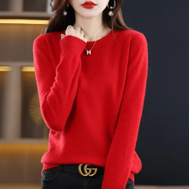 Model wearing the jumper in bright red with black trousers and a belt, hand raised 9