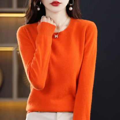 Model wearing the jumper in bright orange, hand raised to her chest to show the ribbed cuff 5