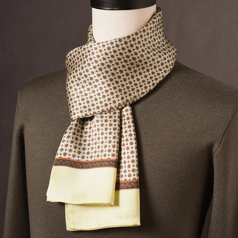 Cream silk scarf with a rust and brown medallion print, a patterned border and plain pale yellow ends, draped on a mannequin. 9