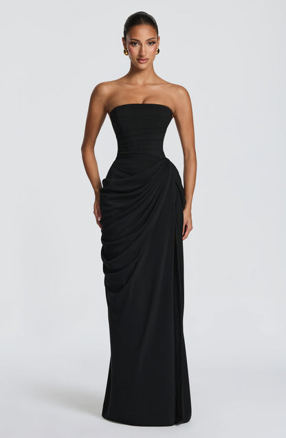 Front view of the black strapless maxi dress, showing the ruched corset bodice and draped skirt gathered at one hip. 31
