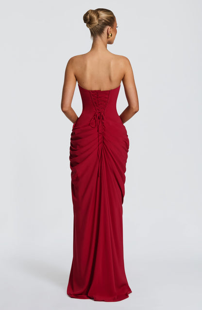 Back view of the red dress showing the lace-up corset back with trailing ties and gathered skirt. 28