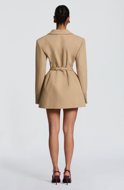 Back view of the camel blazer dress showing a fitted belt with a rectangular buckle, shaped seams and covered cuff buttons. 23