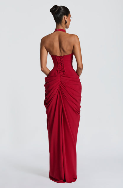 Back view of the deep red dress showing the lace-up corset back, halter clasp and gathered, ruched skirt. 18