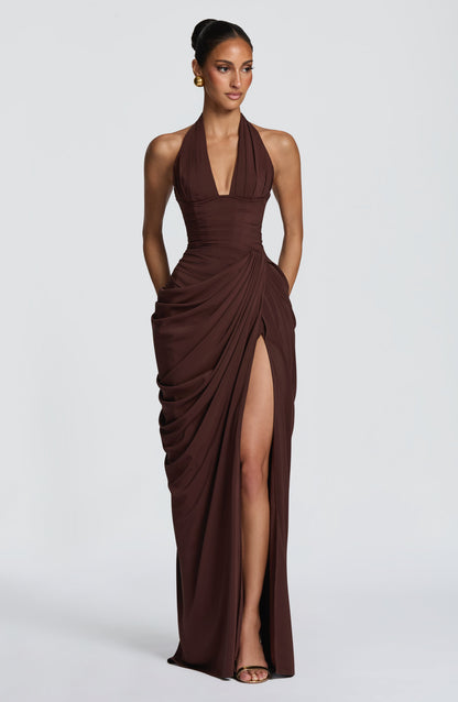 Model in the dark chocolate-brown halterneck gown, front view, with draped chiffon skirt and a high thigh split. 24