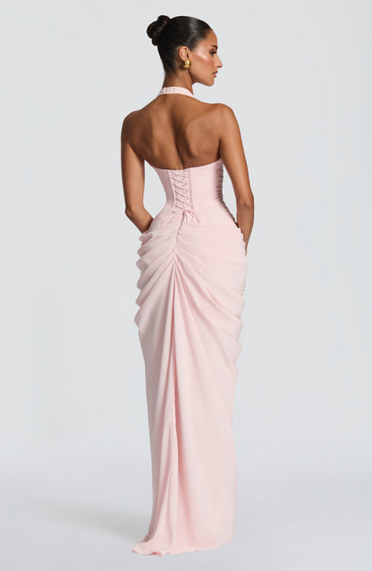 Back view of the pale pink dress showing the corset lacing and ruched skirt, with the model's head turned slightly to the side. 7