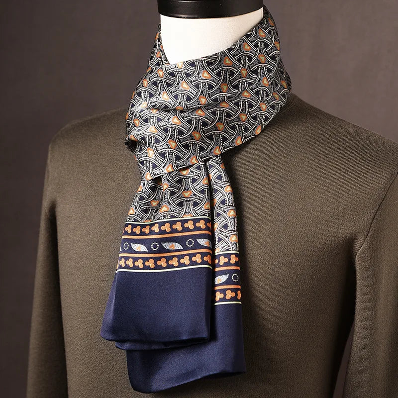 Navy silk scarf with an interlocking arch pattern in orange and white, a patterned border and plain navy ends, draped on a mannequin. 11