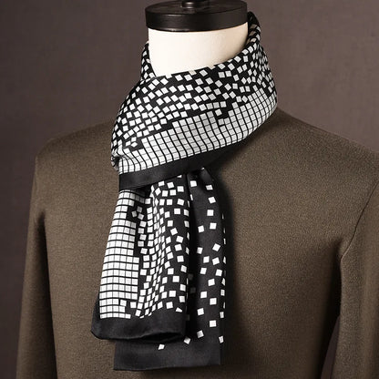 Black and white silk scarf with a scattered square mosaic pattern and black edging, draped on a mannequin over an olive jumper. 13