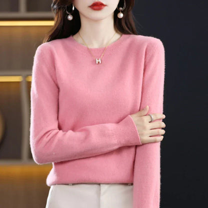 Model wearing the jumper in pink with cream trousers, arms folded across her body 10