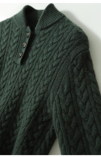 Angled close-up of the dark green cable-knit sweater showing the braided cable pattern across the body and sleeve, with the buttoned collar. 20