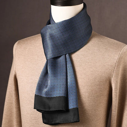 Blue silk scarf with a fine woven-look geometric pattern and plain black ends, draped on a mannequin over a beige jumper. 3