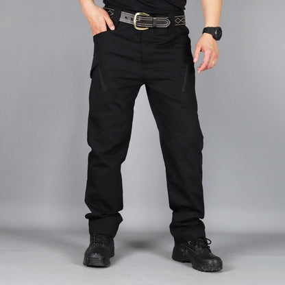 Front view of black trousers worn with a belt, watch and black boots, one hand resting in the side pocket. 5