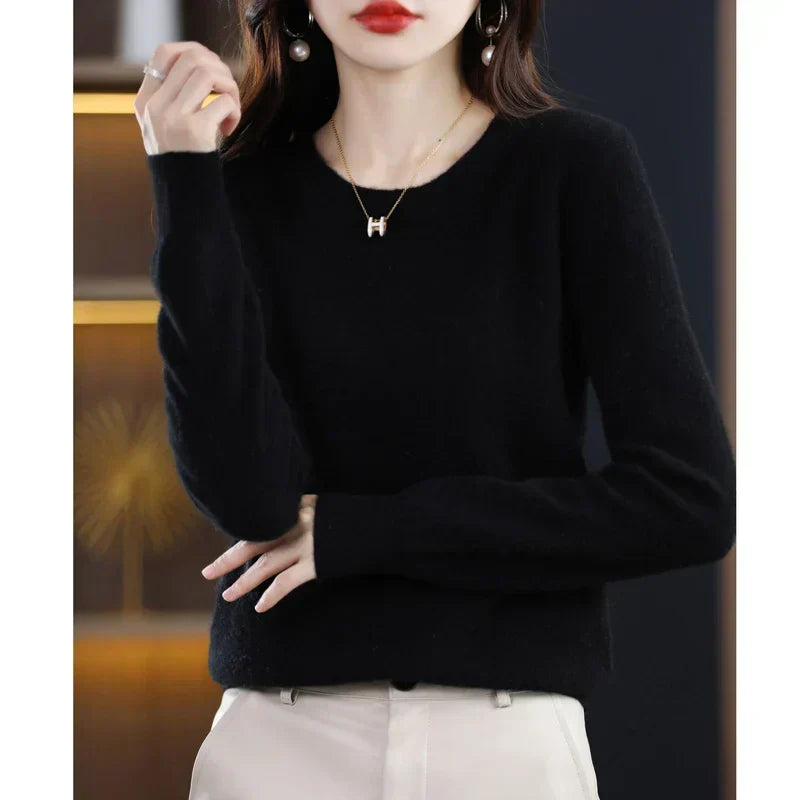 Model wearing the jumper in black with cream trousers, one hand raised and one resting low 19
