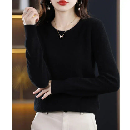 Model wearing the jumper in black with cream trousers, one hand raised and one resting low 19