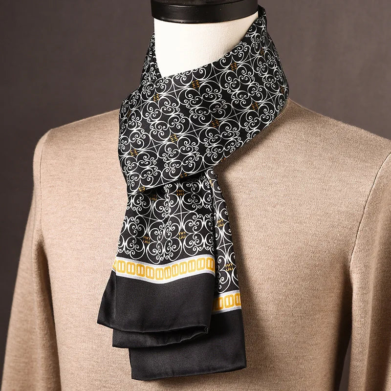 Black silk scarf with a white scrollwork pattern and a yellow and white patterned border, draped on a mannequin. 25