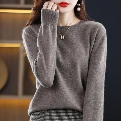 Model wearing the jumper in taupe-grey with a hand raised to her face, ribbed cuff visible 4