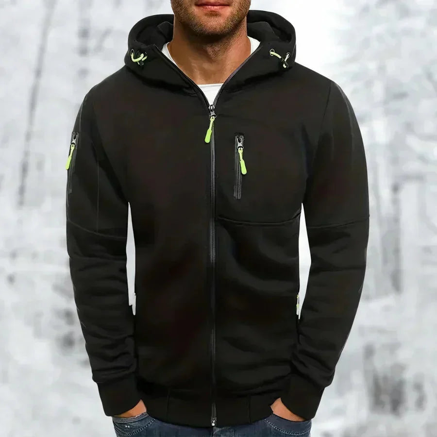 Model wearing the hoodie in black with bright lime green zip pulls and drawcords, set against a snowy woodland backdrop. 7