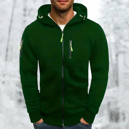 Model wearing the hoodie in dark green with lime green zip pulls and hood drawcords, hands in pockets, in a snowy scene. 6